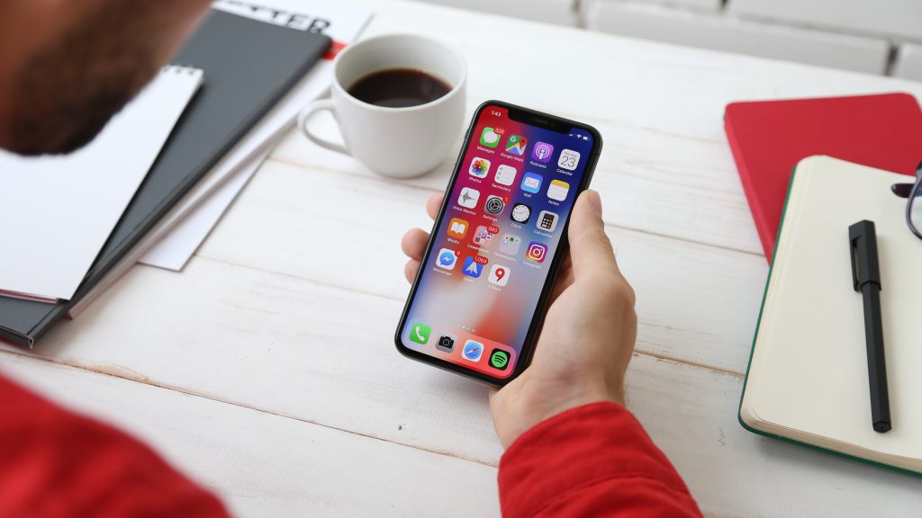 man holding smartphone showing mobile apps