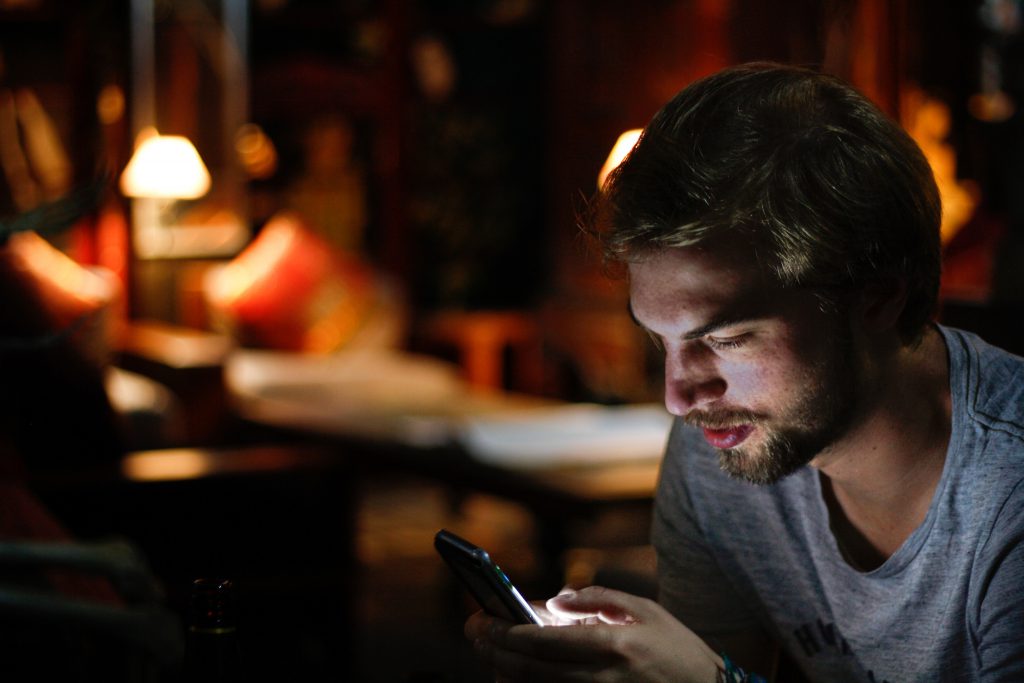 Man looking at his smartphone for aso competitor analysis